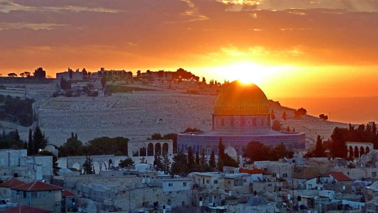 Jerusalem's Dome of the Rock and Old City skyline at sunset viewed from across the valley with the Mount of Olives in the foreground